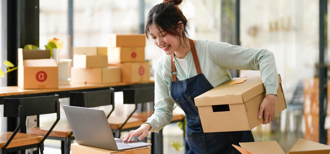 Woman applies a Canada Post return label to a package