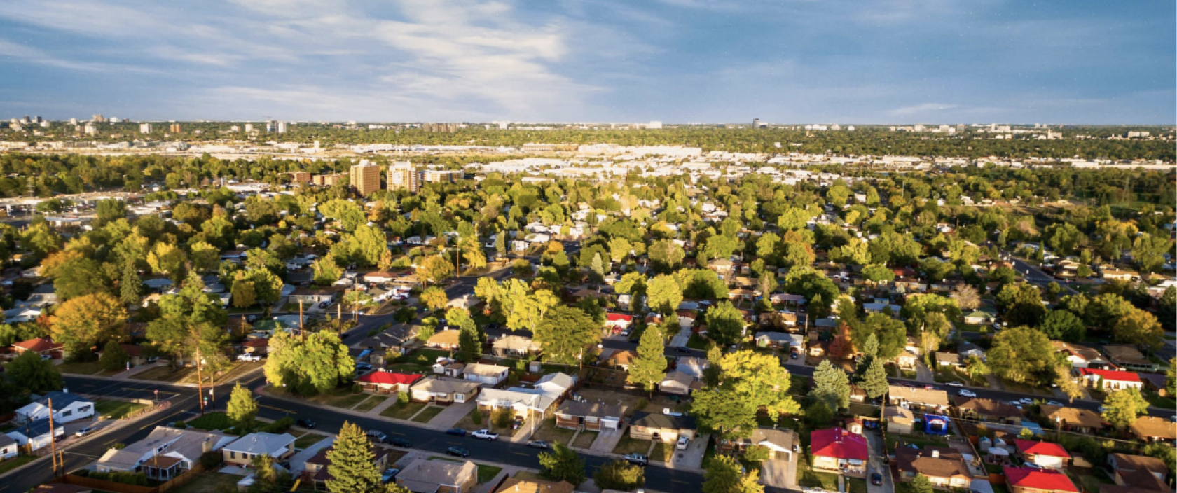 Vue aérienne d’un vaste quartier rempli de maisons, de cours et d’arbres.